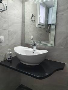 a white sink on a black counter in a bathroom at Amaltheia in Agios Dimitrios