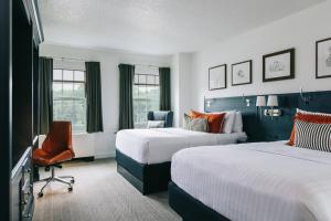 a hotel room with two beds and a chair at College Park Marriott Hotel & Conference Center in College Park