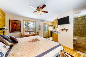 a bedroom with a bed and a flat screen tv at Wapiti Point - Guest House in Grand Lake