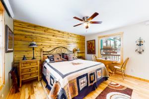 a bedroom with a bed and a wooden wall at Wapiti Point - Guest House in Grand Lake