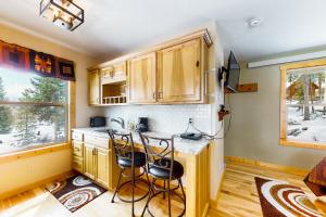 a kitchen with wooden cabinets and a counter with stools at Wapiti Point - Guest House in Grand Lake