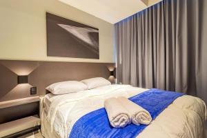 a bedroom with a bed with two towels on it at TOLIVE One Housi Recife by Carpediem in Recife
