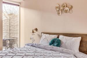 a bedroom with a bed with white pillows and a window at ARI Central Apartment 2 in Arad