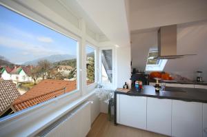 uma cozinha com uma grande janela e um balcão de cozinha em De luxe Apartment GOLOB Kranjska Gora em Kranjska Gora