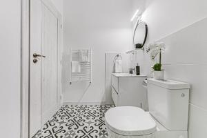 a white bathroom with a toilet and a sink at ARI Central Apartment 2 in Arad