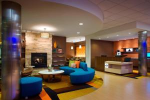 a living room with blue furniture and a fireplace at Fairfield Inn & Suites by Marriott Tustin Orange County in Tustin