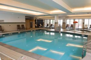 a large swimming pool in a hotel lobby at Courtyard by Marriott Erie Ambassador Conference Center in Erie