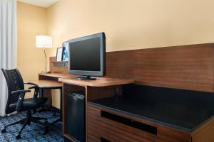 Habitación de hotel con escritorio y TV. en Fairfield Inn Roseville, en Roseville