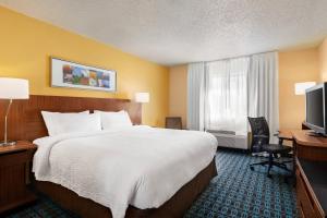a hotel room with a bed and a desk and a television at Fairfield Inn Roseville in Roseville