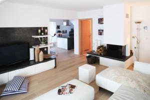 ein Wohnzimmer mit weißen Möbeln und einem weißen Sofa in der Unterkunft De luxe Apartment GOLOB Kranjska Gora in Kranjska Gora