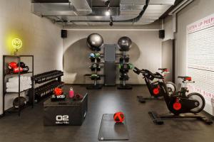 a gym with bikes and exercise equipment in a room at Moxy Bern Expo in Bern