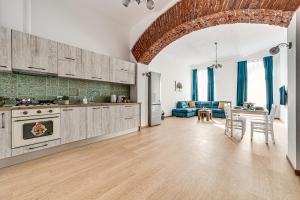 an open kitchen and living room with a blue couch at Ultra Central Apartment with Private Terrace in Arad