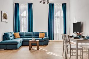 a living room with a blue couch and a table at ARI Central Apartment 2 in Arad
