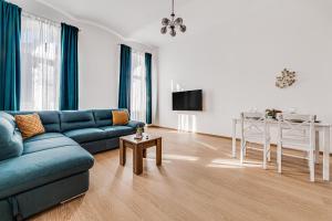 ein Wohnzimmer mit einem blauen Sofa und einem Tisch in der Unterkunft ARI Central Apartment 2 in Arad