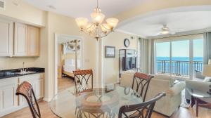 a kitchen and dining room with a glass table and chairs at Legacy II 1008 in Gulfport