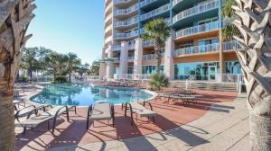 a swimming pool with chairs and a building at Legacy II 1008 in Gulfport