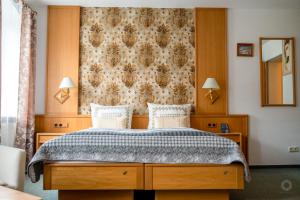 a bedroom with a bed and a wall with a curtain at Wild West Hotel in Fichtelberg