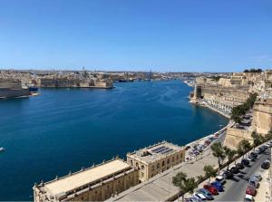 uma vista para um rio com carros estacionados ao lado de uma cidade em Valletta 3 Bedroom Apartment em Valletta