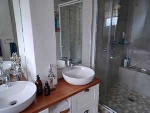 a bathroom with two sinks and a shower at Corner Delight Full Back up power in Hermanus