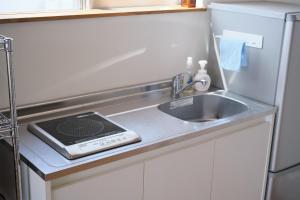 a kitchen counter with a sink next to a refrigerator at Rush Awaji Guppy - Seaside Holiday Home - Self Check-In Only in Awaji