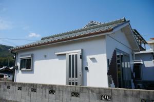una casa blanca con una valla delante en Rush Awaji Guppy - Seaside Holiday Home - Self Check-In Only, en Awaji