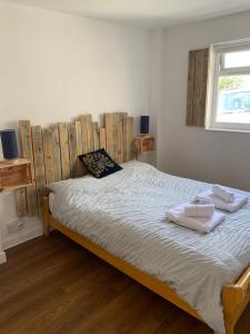 a bedroom with a bed with towels on it at The Hen House in Bere Alston