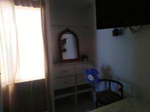 a bedroom with a dresser and a mirror and a chair at El Refugio in Punta Hermosa