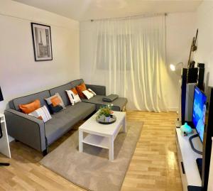 a living room with a couch and a table at Bel Appart Alfortville -Quai Seine - 5mn de Paris in Alfortville