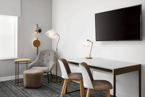 普蘭特城的住宿－TownePlace Suites by Marriott Plant City，客房设有书桌、两把椅子和电视。