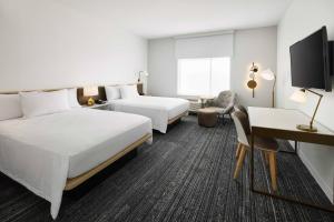 a hotel room with two beds and a desk at TownePlace Suites by Marriott Plant City in Plant City