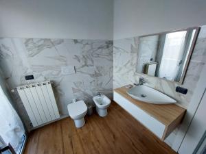 y baño con lavabo, aseo y espejo. en Appartamento privato con jacuzzi, en Legnano