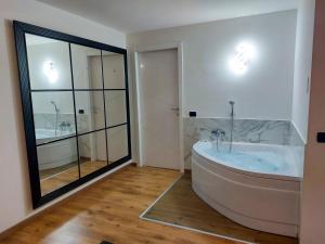 uma banheira na casa de banho com uma grande janela em Appartamento privato con jacuzzi em Legnano