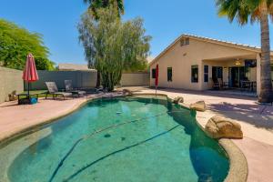 a swimming pool in front of a house at 5 Mi to Dtwn Gilbert Home with Pool and Patio in Gilbert