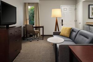 sala de estar con sofá y TV en Residence Inn by Marriott Seattle/Bellevue en Bellevue