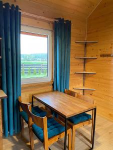 ein Esszimmer mit einem Tisch, Stühlen und einem Fenster in der Unterkunft Bella Przystań in Zator