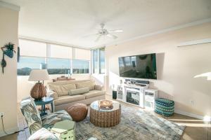 a living room with a couch and a tv at Ocean Club 703 in Biloxi