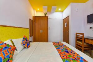 a bedroom with a bed and a desk in it at AIRPORT SKY INN HOMESTAY in Jaipur