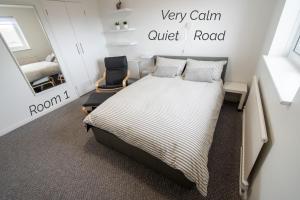 a bedroom with a bed and a chair and a mirror at Town House Chantry - With Self Check In and Free Parking - Rooms at ipswichdigs in Ipswich
