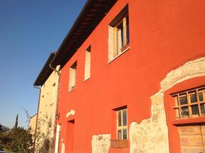 un edificio rojo con ventanas laterales en Il Glicine 3, en San Gimignano