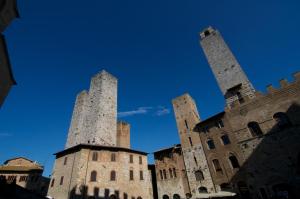 dos torres de un castillo con un cielo azul en el fondo en Il Glicine 3, en San Gimignano