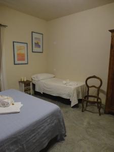 una habitación de hotel con 2 camas y una silla en Il Glicine 3, en San Gimignano