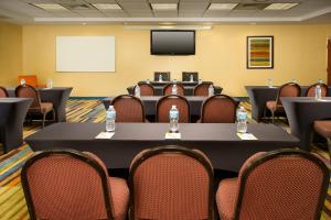a conference room with tables and chairs and a screen at Fairfield Inn & Suites by Marriott Marshall in Marshall