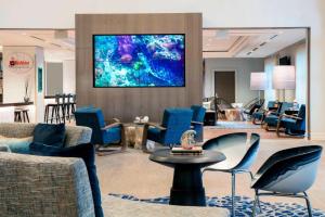 a lobby with blue chairs and a large painting on the wall at Renaissance Fort Lauderdale Cruise Port Hotel in Fort Lauderdale