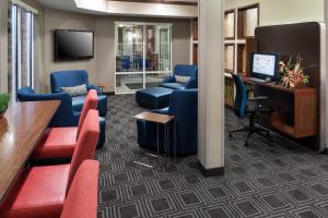 a lobby with chairs and a desk and a television at TownePlace Suites by Marriott Little Rock West in Little Rock