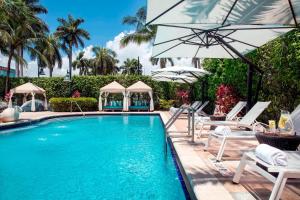 a swimming pool with chairs and umbrellas at Renaissance Fort Lauderdale Cruise Port Hotel in Fort Lauderdale