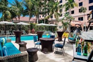 a patio with tables and chairs next to a pool at Renaissance Fort Lauderdale Cruise Port Hotel in Fort Lauderdale