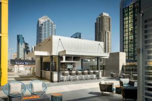 a rooftop patio with a bar with chairs and skyscrapers at SpringHill Suites by Marriott San Diego Downtown/Bayfront in San Diego