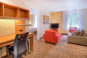a hotel room with a desk and a living room at TownePlace Suites Raleigh Cary/Weston Parkway in Cary