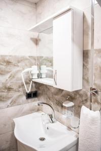 W białej łazience znajduje się umywalka i lustro. w obiekcie Galapera Hotel w Stambule