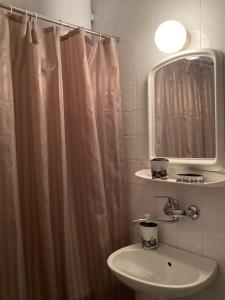 een badkamer met een wastafel en een douchegordijn bij TA&TI in Ohrid